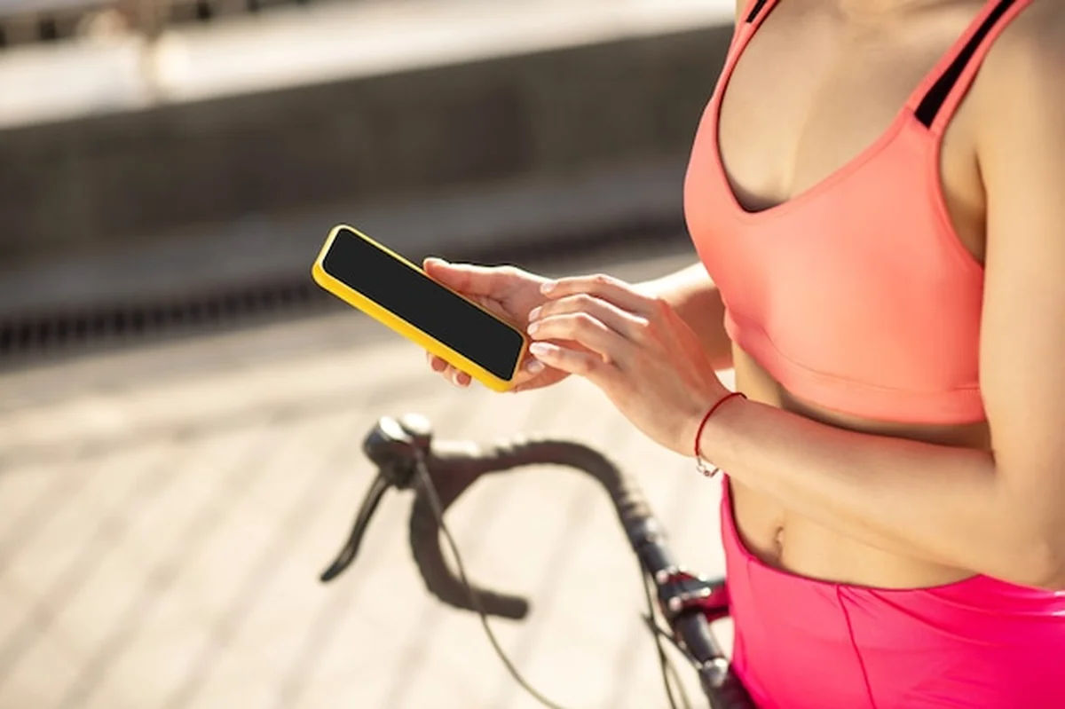 Dziewczyna w odzieży sportowej trzymająca smartfon