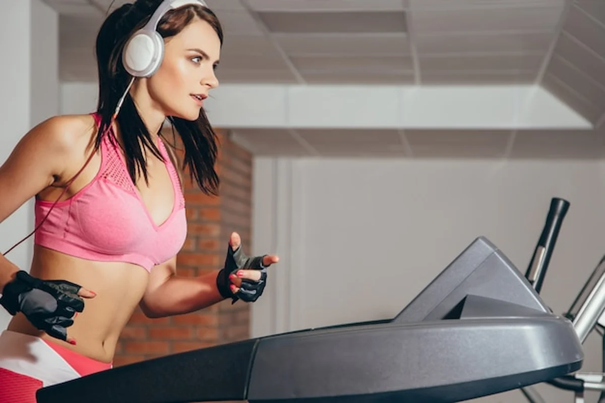 Kobieta ćwiczy cardio na bieżni w siłowni