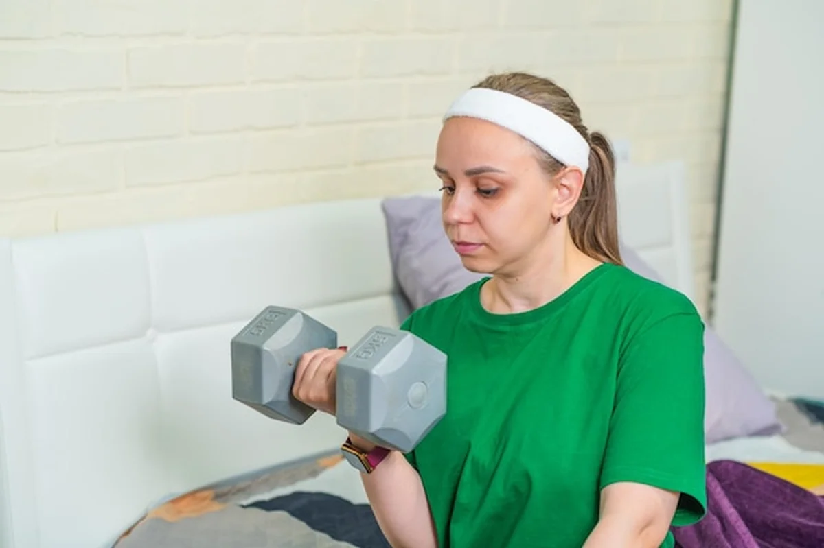 Młoda kobieta ćwiczy z halterem w studiu fitness