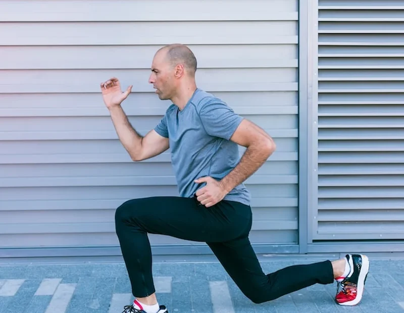 Mężczyzna biegacz robi rozciąganie przed treningiem