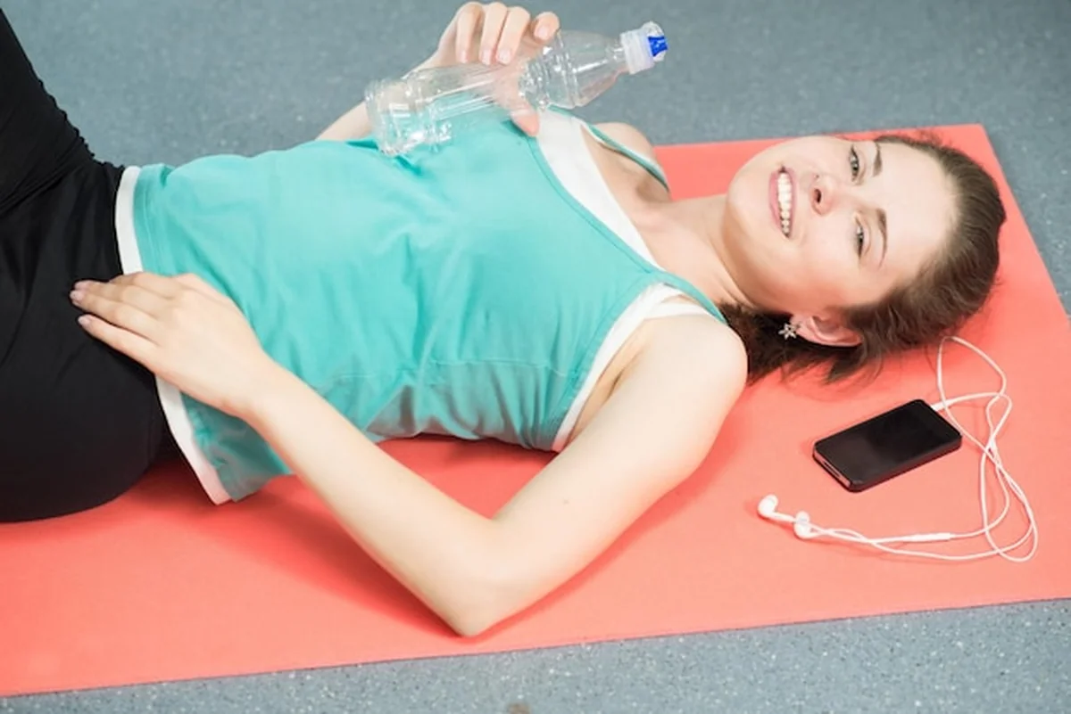 Piękna dziewczyna leży na macie po treningu